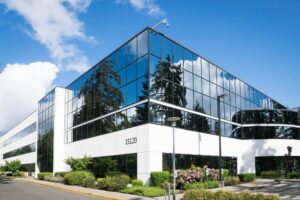 Home Contemporary office building in Redmond with reflective glass and lush greenery, captured on a sunny day.